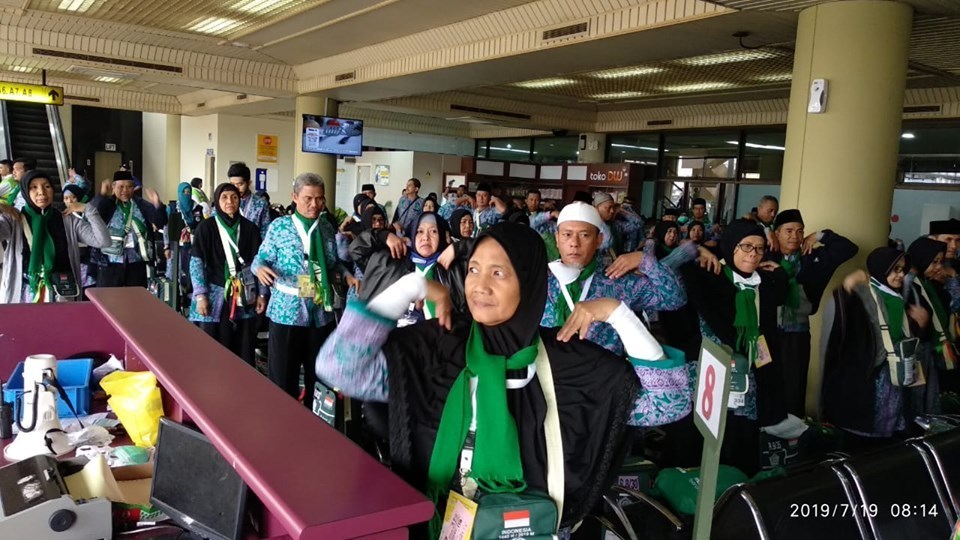 JCH Kloter 15 sedang melakukan senam peregangan otot di ruang tunggu Bandara Hang Nadim jelang keberangkatan, Jumat (19/7/2019). (istimewa)