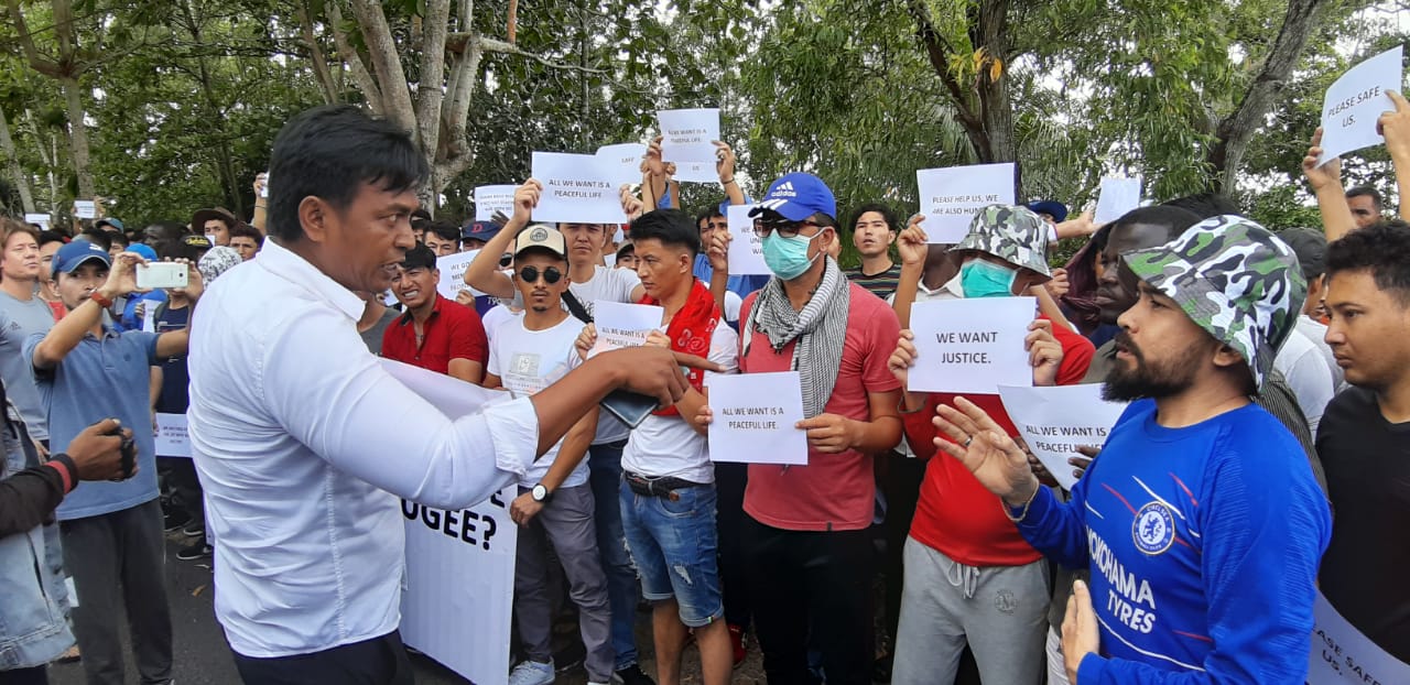 Kasat Intelkam Polres Bintan, AKP Yudiarta Rustam, saat berbicara dengan para pengungsi yang melakukan aksi demo di Kantor IOM di Jalan Peralatan Km 7 Tanjungpinang, Senin (5/7/2019) pagi. (okialexander/haluankepri.com)