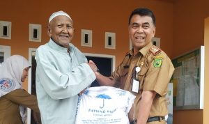 Sekdakab Natuna, Wan Siswandi menyerahkan beras CPP kepada masyarakat. (fatur/haluankepri.com)