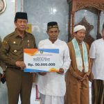 Plt Gubernur Kepri, Isdianto menyerahkan bantuan kepada pengurus Masjid Almanar.(fatur/haluankepri.com)