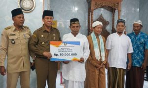 Plt Gubernur Kepri, Isdianto menyerahkan bantuan kepada pengurus Masjid Almanar.(fatur/haluankepri.com)
