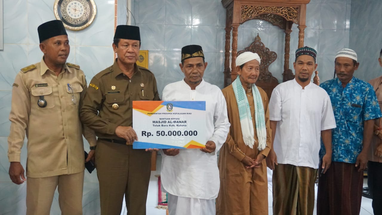 Plt Gubernur Kepri, Isdianto menyerahkan bantuan kepada pengurus Masjid Almanar.(fatur/haluankepri.com)