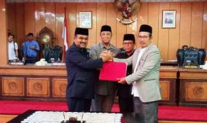 Ketua DPRD Karimun Yusuf Sirat bersalaman dengan Bupati Karimun pada saat pengesahaan APBD Karimun 2020 di Gedung Balai Long Sri DPRD Karimun, Jumat (29/11/2019) malam. (hengki/haluankepri.com)