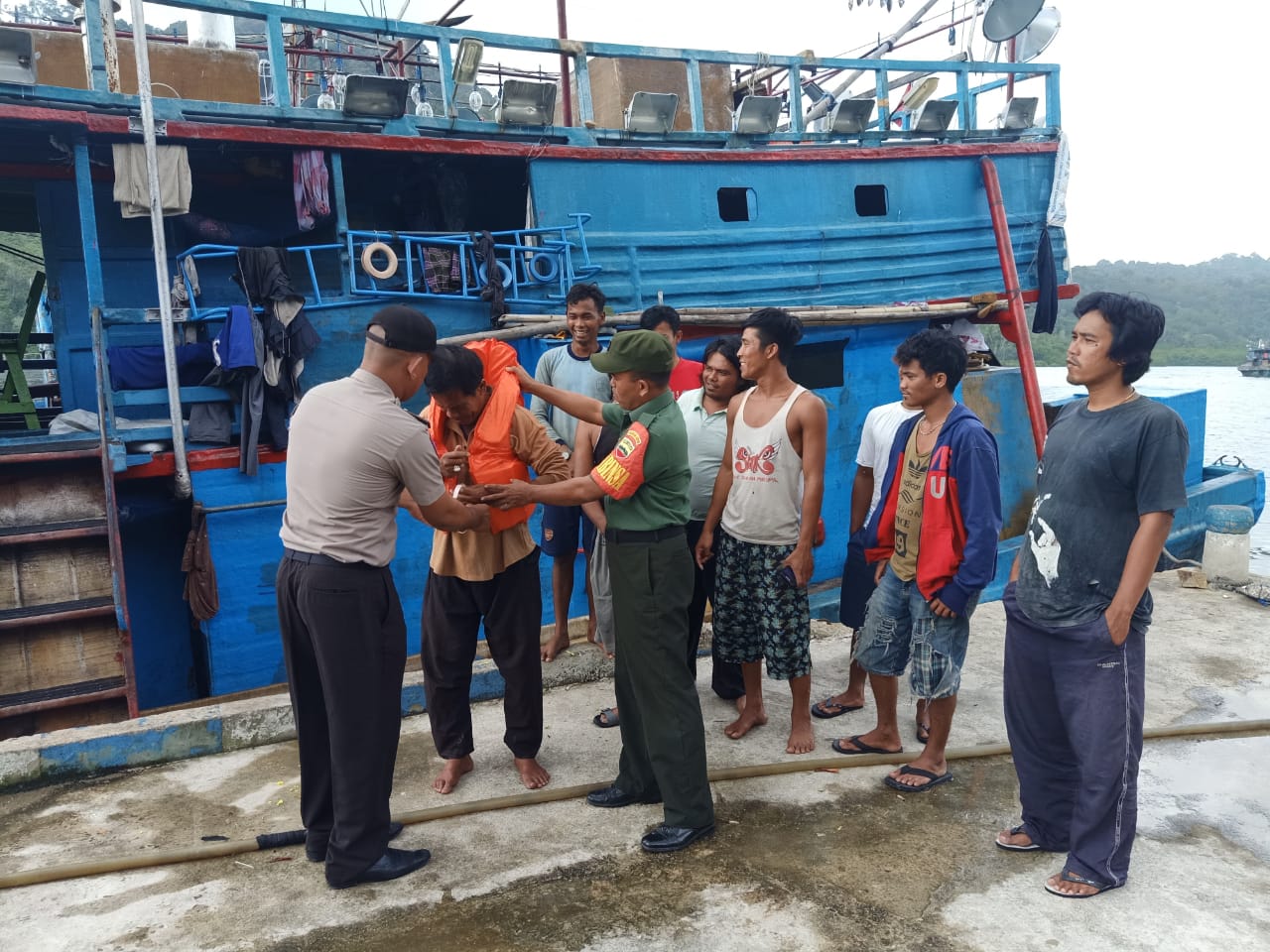 Babinkamtibmas dan Babinsa memasangkan life jacket kepada nelayan. (istimewa)