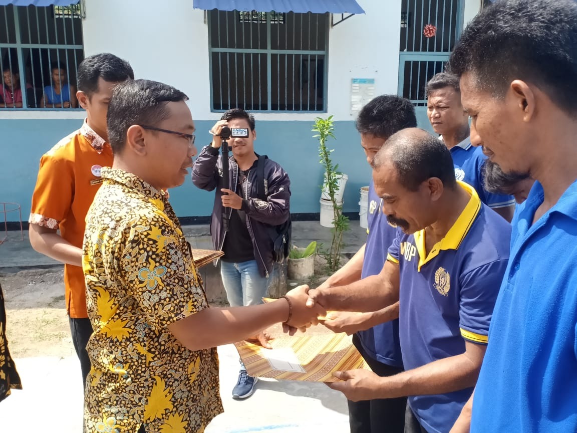 Kasubsi Pelayanan Tahanan Rutan Karimun, Novi Irwan saat menyerahkan surat remisi kepada warga binaan. (ilham/haluankepri.com)