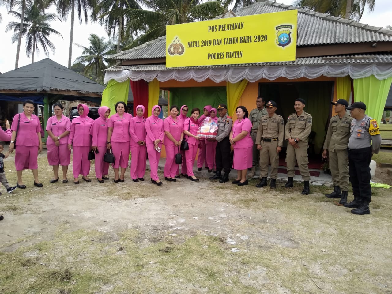 Ketua Bhayangari cabang Polres Bintan Ny Leni Boy Herlambang bersama pengurus menyerahkan parsel kepada petugas berjaga di Pos Yan Pantai Trikora, Senin (30/12/2019) sore kemarin. (istimewa)