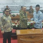 Ketua DPRD Natuna, Andes Putra menyerahkan buku Perda kepada Bupati Natuna Hamid Rizal pada Paripurna pengesahan dua Ranperda. (fatur/haluankepri.com)