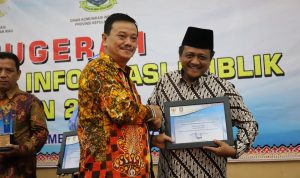 Kabag TU Kemenag Kepri, H. Abu Sufyan (kanan) menerima penghargaan dalam Anugerah Keterbukaan Informasi Publik di Hotel Aston Tanjungpinang, Rabu (4/12/2019) malam. (istimewa)